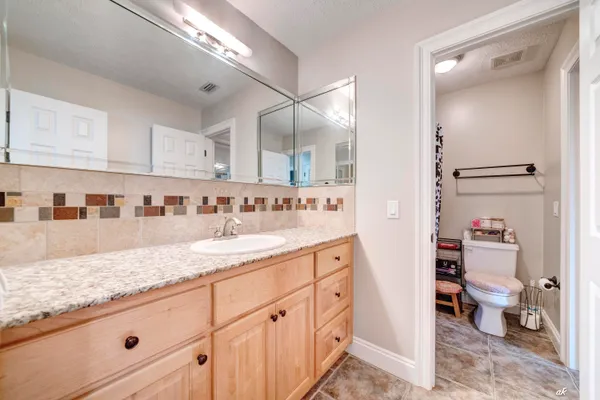 a spacious bathroom with a granite countertop sink and a mirror