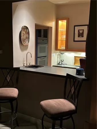 a kitchen with a sink and a stove with wooden floor