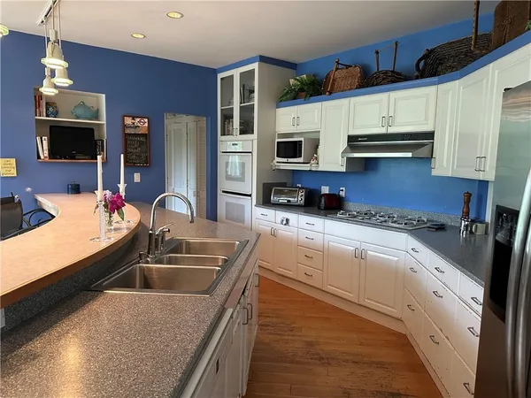a kitchen with stainless steel appliances granite countertop a sink stove and refrigerator
