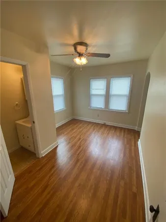 a view of a livingroom with wooden floor and a ceiling fan