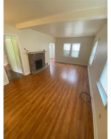 a view of a livingroom with wooden floor and fireplace
