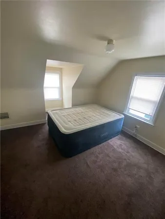 a spacious bedroom with a bed and a window