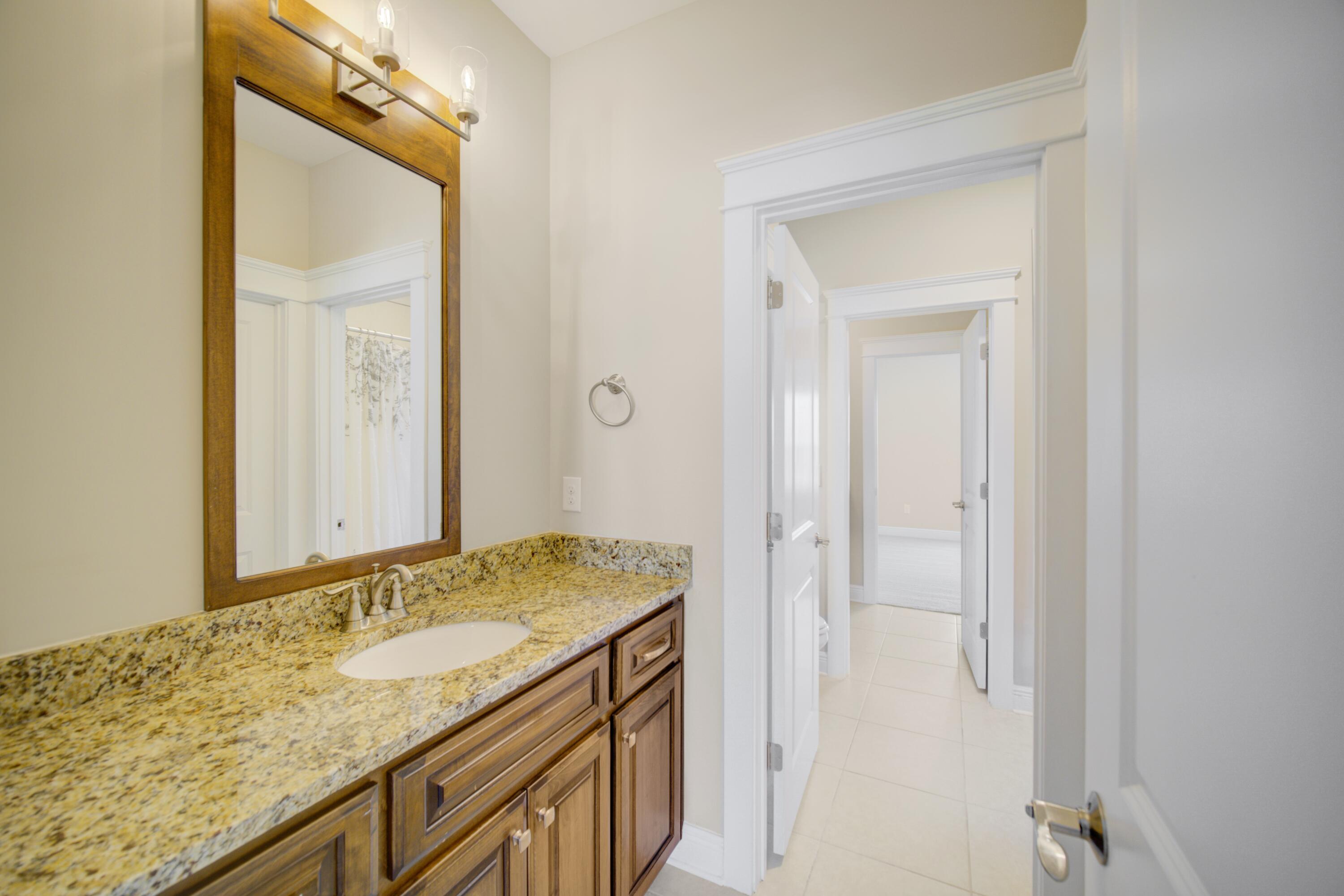 136 Buxtons Way Freeport, FL 32439 - Photo 39 of 59 a bathroom with a granite countertop sink and a mirror