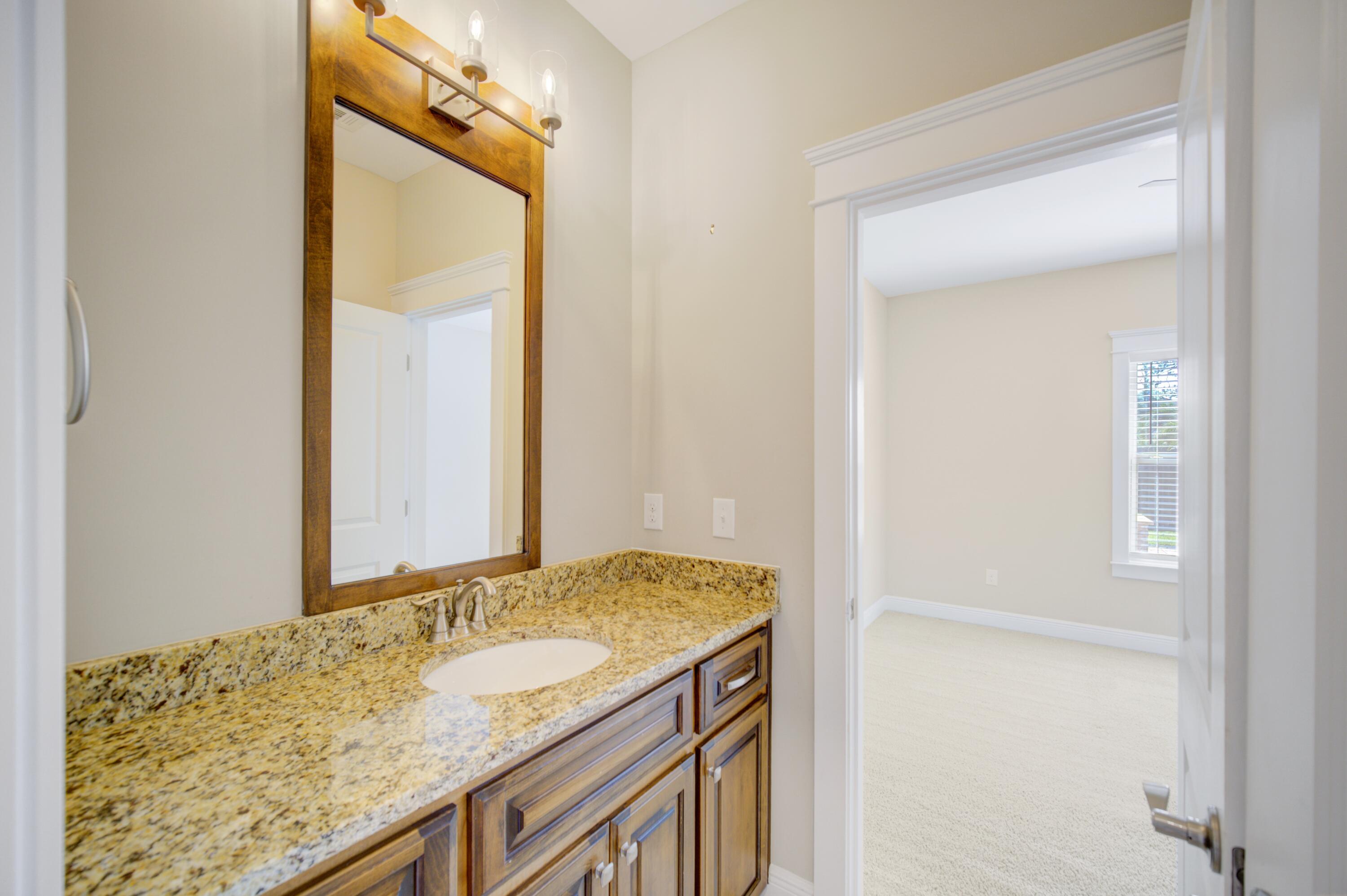 136 Buxtons Way Freeport, FL 32439 - Photo 41 of 59 a bathroom with a granite countertop sink and a mirror