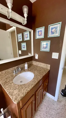a bathroom with a granite countertop sink and a mirror