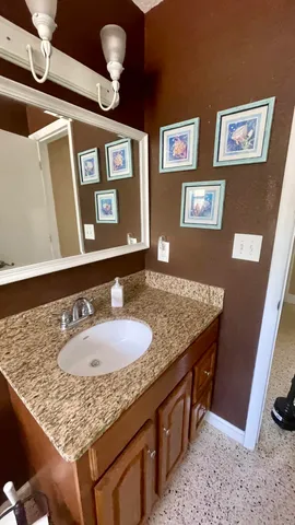a bathroom with a granite countertop sink and a mirror