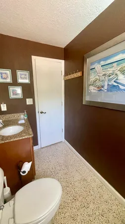 a bathroom with a granite countertop toilet and a shower