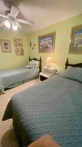 a bedroom with a bed and a lamp on the dresser