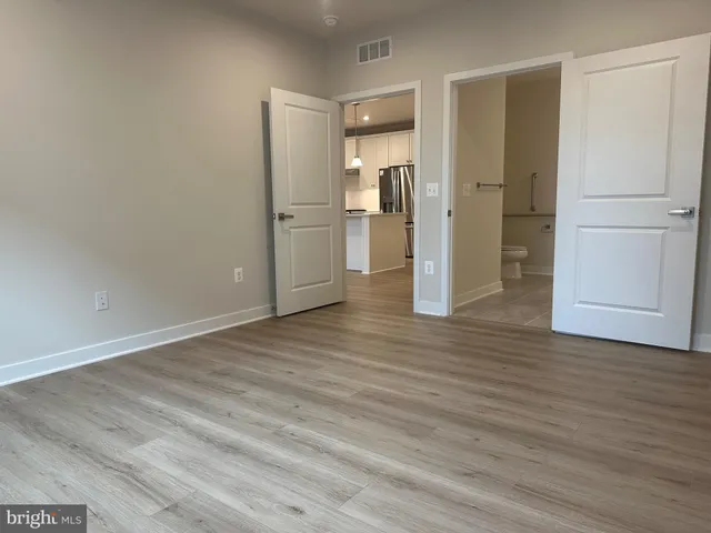 a view of a kitchen with a refrigerator and wooden floor