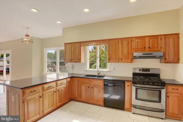 a kitchen with stainless steel appliances granite countertop a stove a sink and a microwave