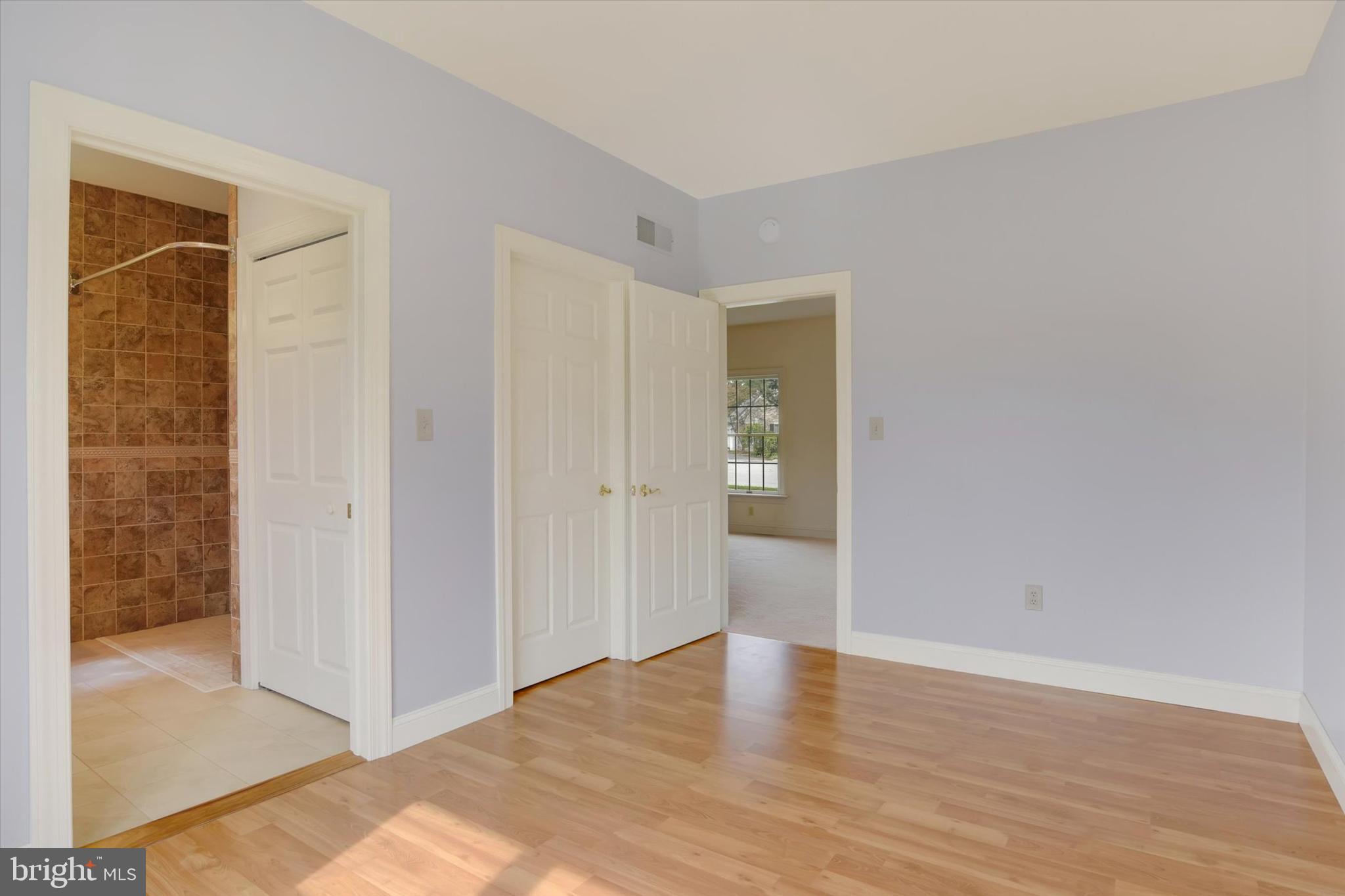 4420 Rathlin Court Harrisburg, PA 17112 - Photo 19 of 41 a view of an empty room with wooden floor and a bathroom
