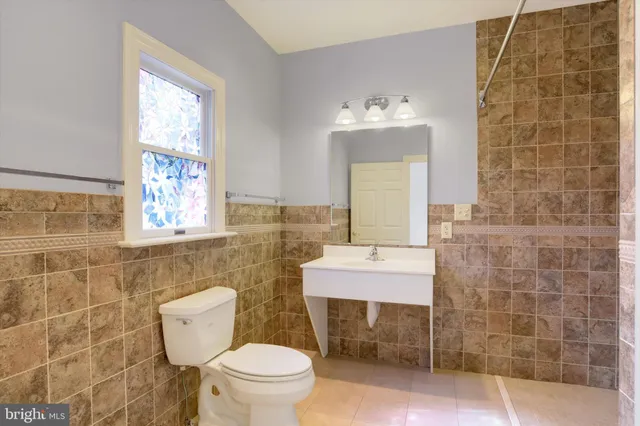 a bathroom with a sink a toilet and mirror