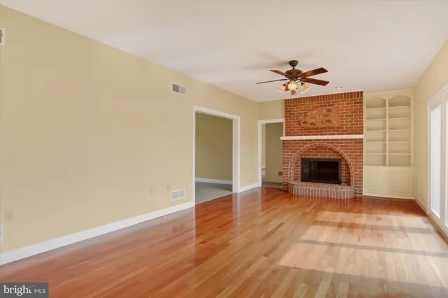 a view of an empty room with a fireplace and a window