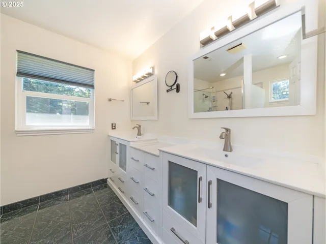 a bathroom with a granite countertop sink a toilet and shower