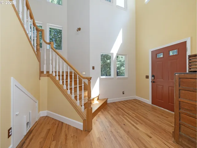 a view of a hallway with wooden floor and staircase