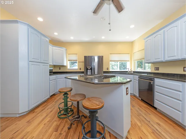 a kitchen with stainless steel appliances granite countertop a sink a stove and a refrigerator