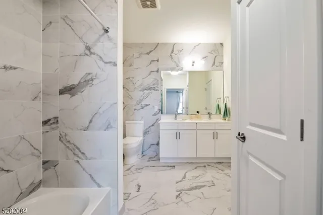 a bathroom with a sink and mirror with bathtub