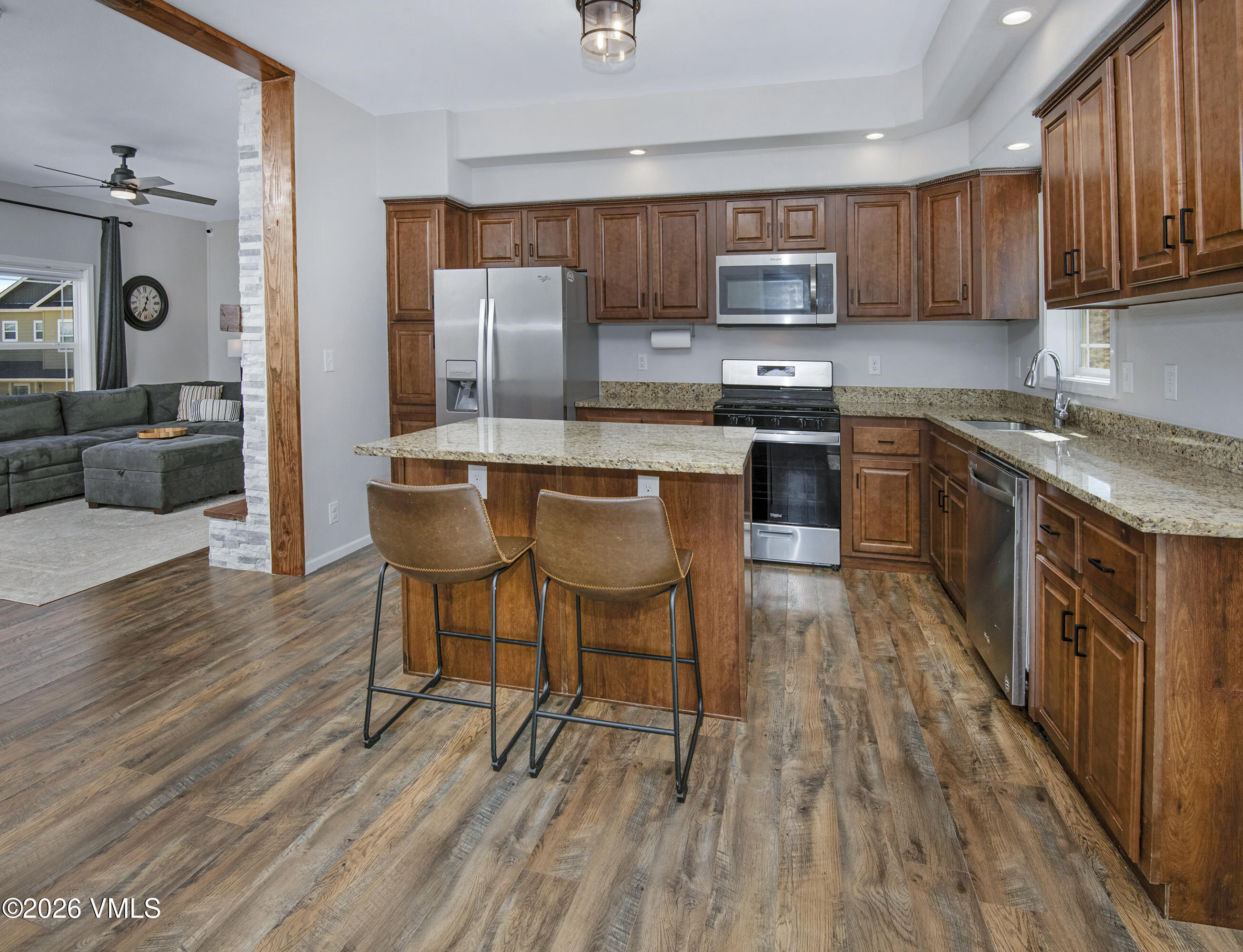 67 Maverick Court Gypsum, CO 81637 - Photo 9 of 40 a kitchen with granite countertop wooden floors wooden cabinets and appliances