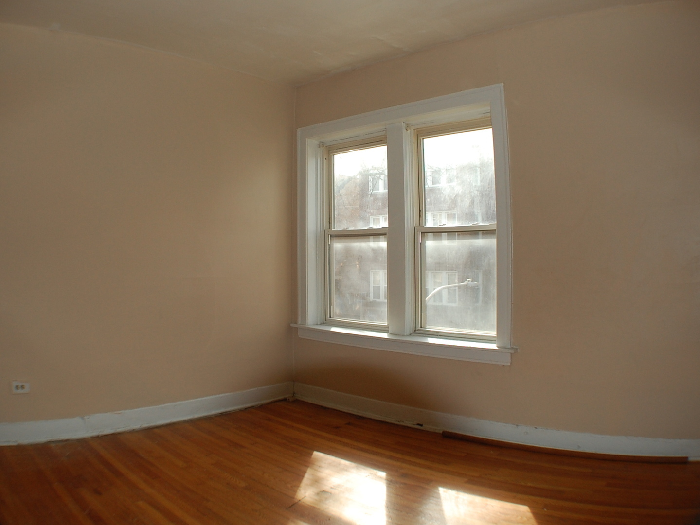 7757 South Paulina Street Chicago, IL 60620 - Photo 11 of 17 an empty room with wooden floor and windows