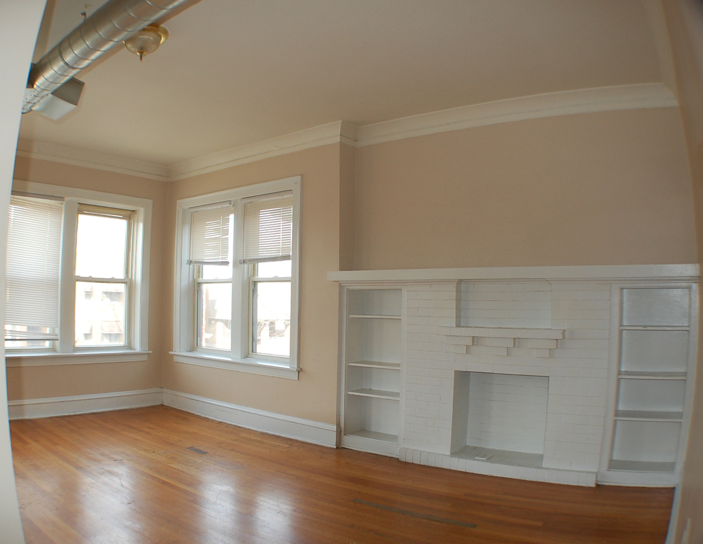 7757 South Paulina Street Chicago, IL 60620 - Photo 5 of 17 an empty room with wooden floor and windows