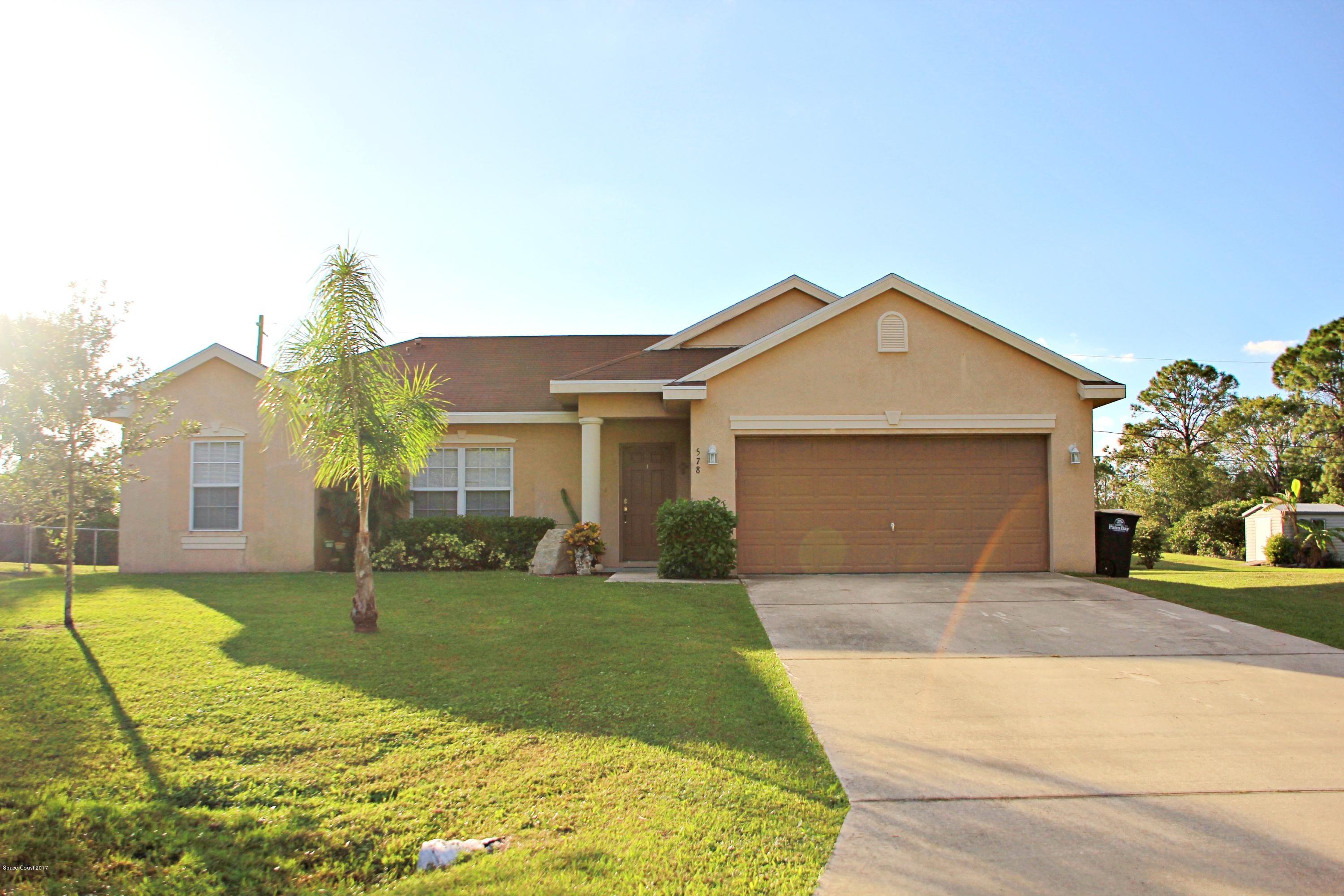 578 Wicker Road Southwest Palm Bay, FL 32908 - Photo 1 of 16 a front view of a house with a yard and garage