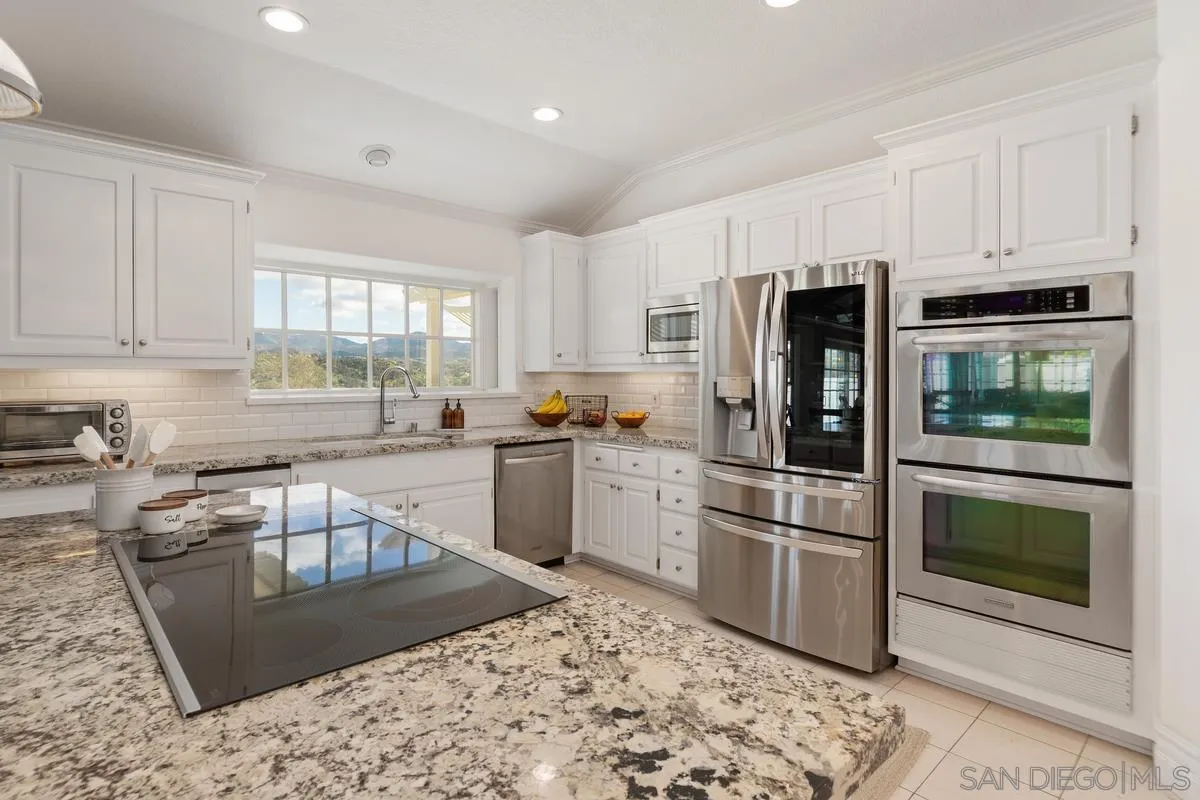 14134 Palisades Drive Poway, CA 92064 - Photo 14 of 32 a kitchen with granite countertop a refrigerator stove and sink