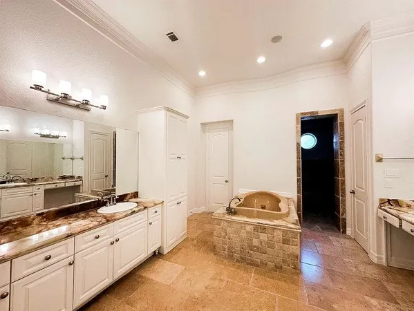 a spacious bathroom with a double vanity sink and mirror