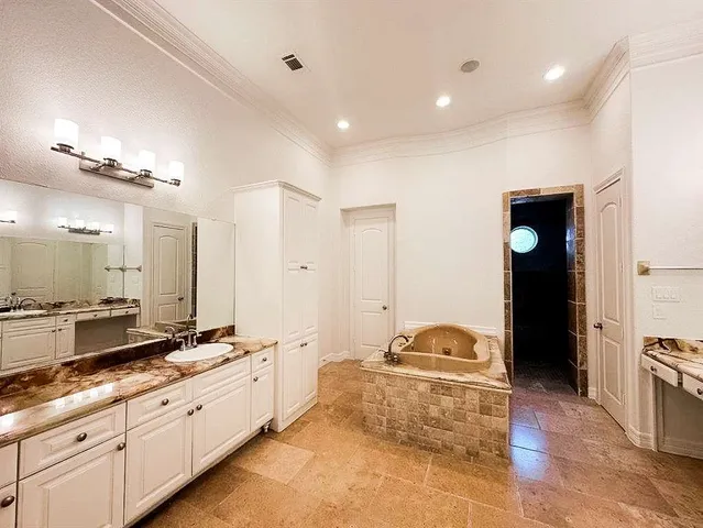 a spacious bathroom with a double vanity sink and mirror