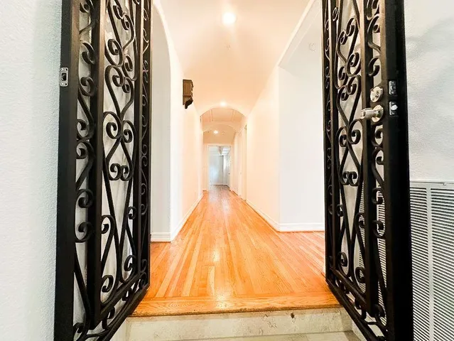 an empty room with windows and chandelier fan