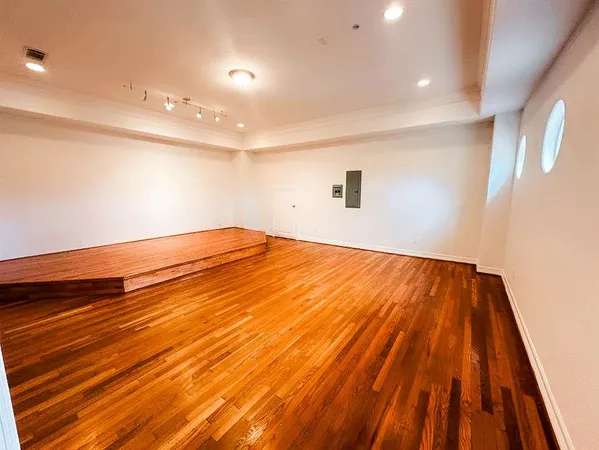 a view of empty room with wooden floor