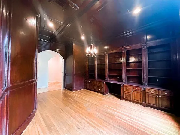 a kitchen with stainless steel appliances kitchen island granite countertop a refrigerator and a wooden floor