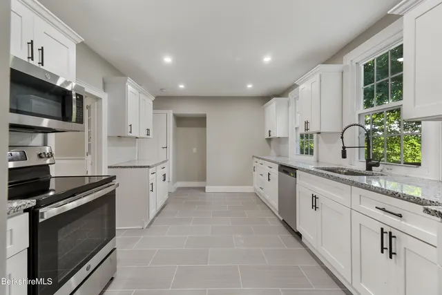 a kitchen with stainless steel appliances a stove sink microwave and cabinets