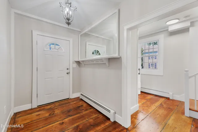 a view of a hallway with closet and wooden floor