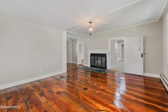 wooden floor in an empty room with a fireplace