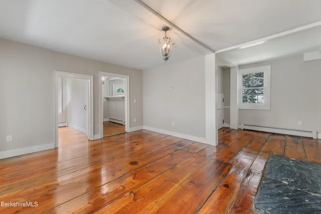 a view of empty room with wooden floor and window