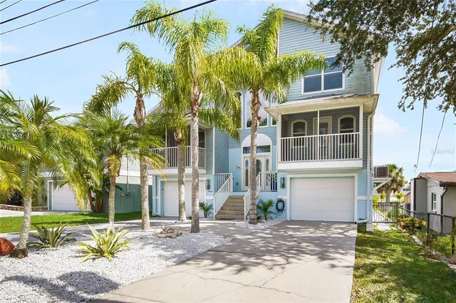 a front view of a house with a yard and trees