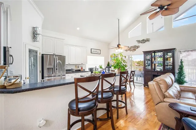 a living room with furniture a chandelier and kitchen view