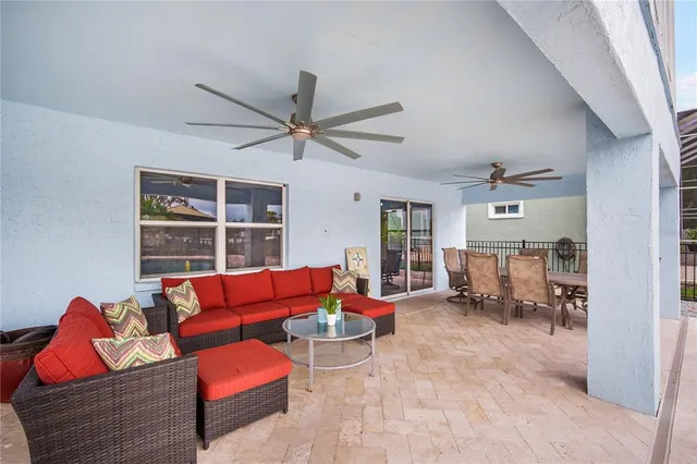 a living room with furniture a ceiling fan and a window