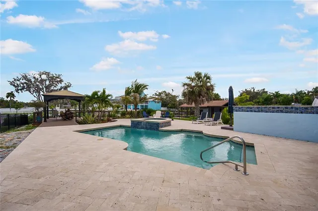 a swimming pool with outdoor seating and lake view