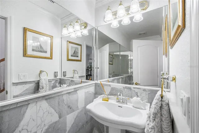 a bathroom with a sink a chandelier and a mirror