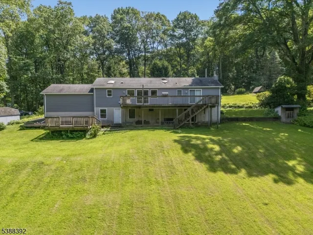 a view of a house with pool table chairs and a yard