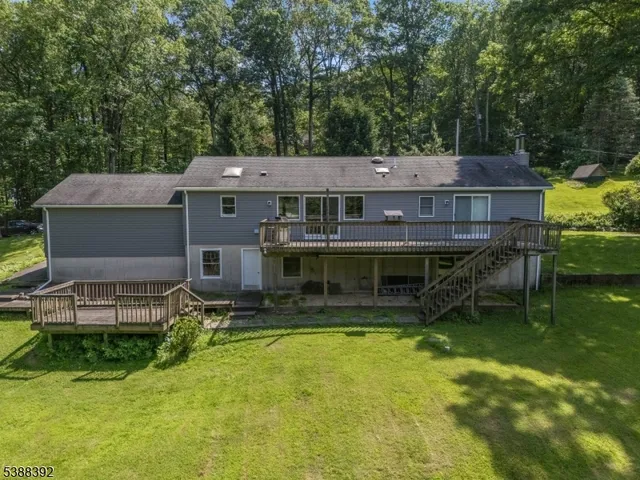 an aerial view of a house with swimming pool next to a yard