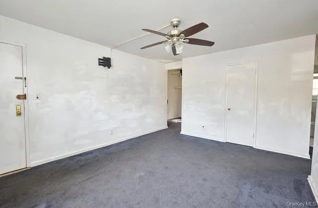 an empty room with a ceiling fan and a window
