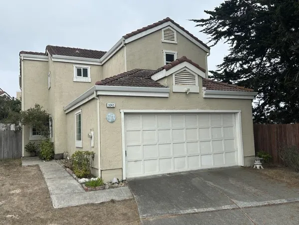 a view of a white house with a outdoor space and garage