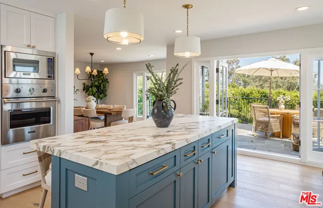 a kitchen with kitchen island a large counter top space appliances and living room view