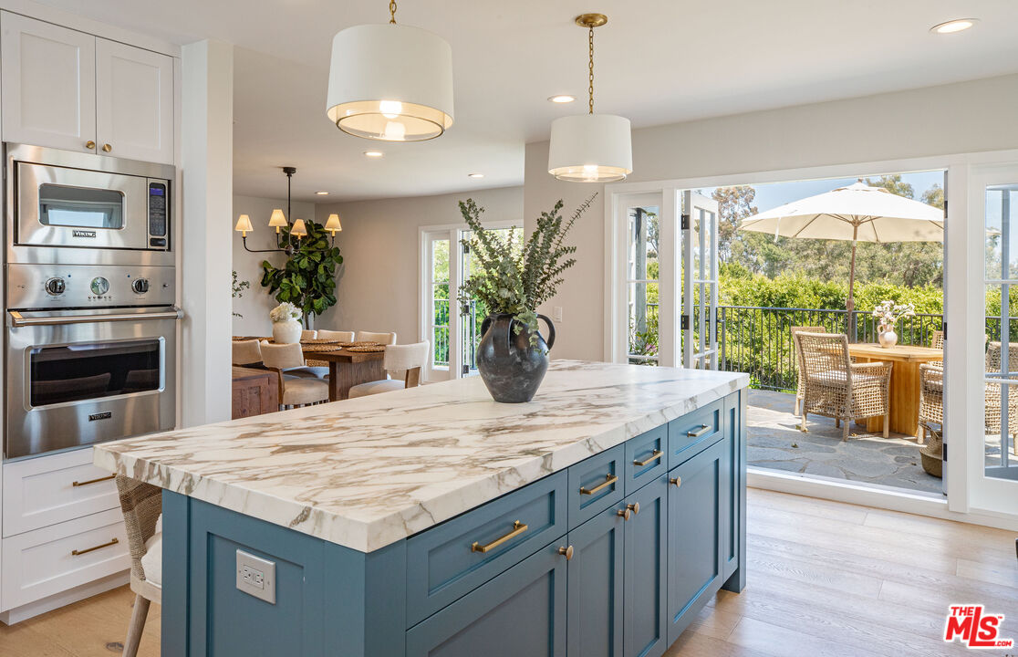 1756 Correa Way Los Angeles, CA 90049 - Photo 14 of 38 a kitchen with kitchen island a large counter top space appliances and living room view