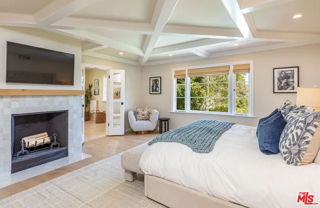 a bedroom with a large bed and a fireplace