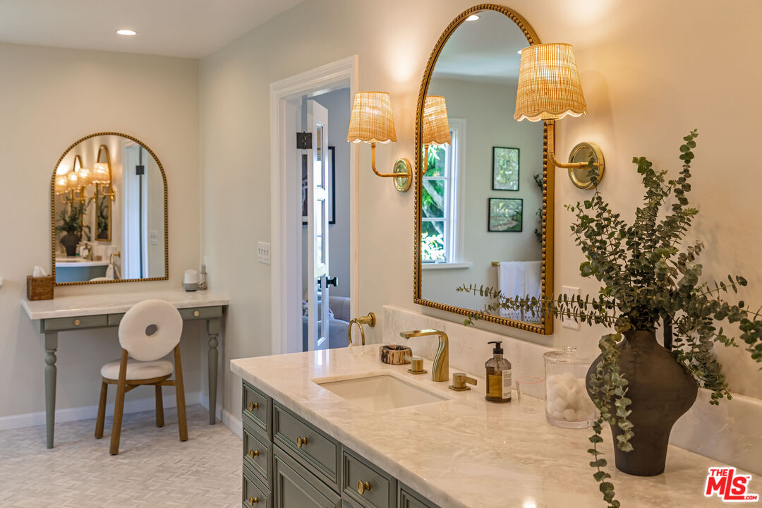 1756 Correa Way Los Angeles, CA 90049 - Photo 19 of 38 a bathroom with a granite countertop sink a mirror and a shower