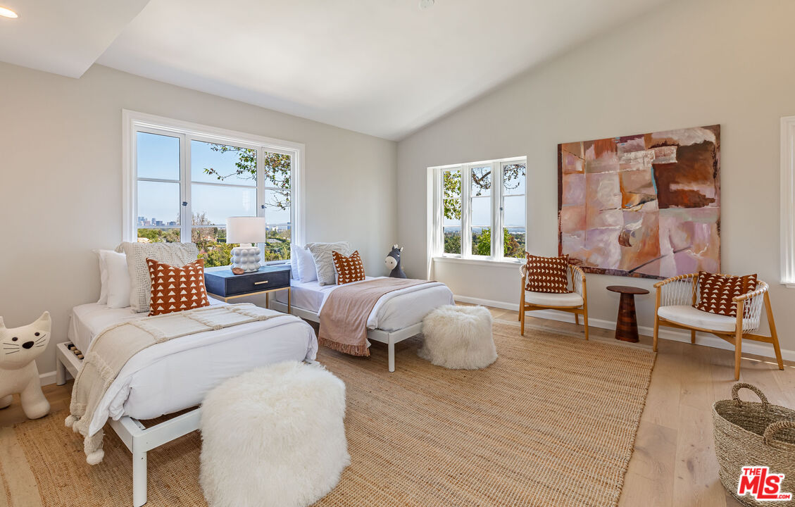 1756 Correa Way Los Angeles, CA 90049 - Photo 22 of 38 a bedroom with two beds and a large mirror next to a window