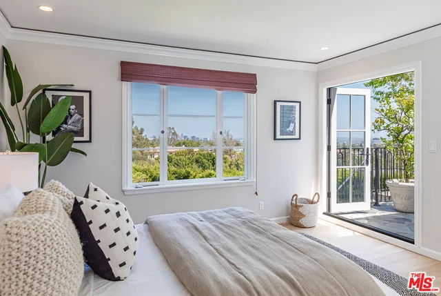 a bedroom with a bed and a large window